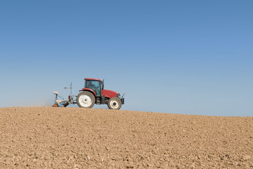 Obraz premium tractor in a field on blue sky background