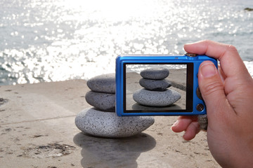 person taking a photo of zen stones