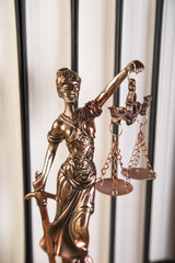 Lady of justice, wooden & gold gavel and books on wooden table