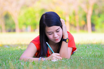 Portrait of a pretty young woman writing in her diary at outdoor