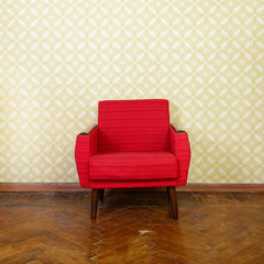 Vintage room with old fashioned red armchair, wallpaper and weat