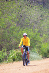 Fototapeta premium young man riding mountain bike in dusty road use for sport leisu