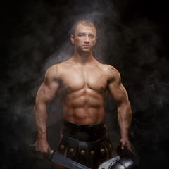 Fototapeta na wymiar Gladiator standing in a smoke with helmet and sword