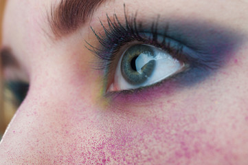 Fototapeta na wymiar Bright colorful creative make-up on woman eye with powder on ski