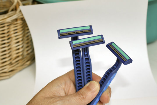 mano sujetando maquinillas de afeitar