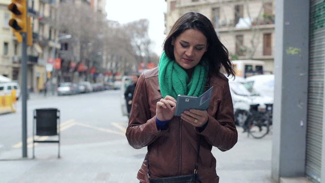 Woman texting on smartphone, walking in the city