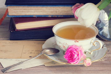 old books and mail with cup of tea