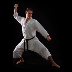 karate man with black belt posing, champion of the world on blac © Khorzhevska