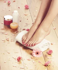 Foto op Canvas Spa background with beautiful legs, flowers and petals © Acronym