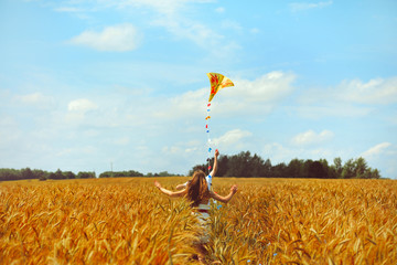 Young couple in love running with a kite in a yellow box