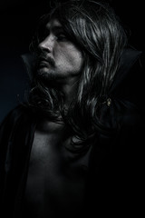 Vampire with black coat and long hair, blue light