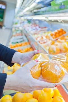 Packaged orange with woman hand in the supermarket