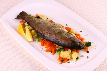 Fried whole trout with vegetables and lemon