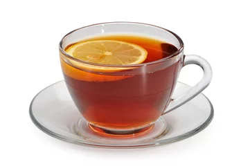 Papier Peint photo Theé Tasse en verre avec du thé et un citron sur une soucoupe en verre