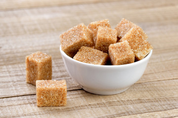 Cane sugar in bowl on wooden table