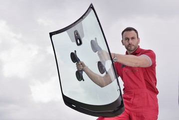 mechanic holding windshield