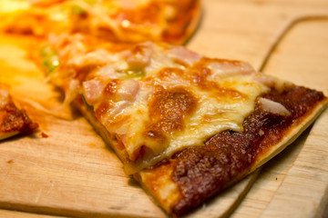 slice cheese of pizza is lifted from the pan