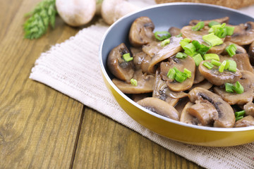 Delicious fried mushrooms in pan on table close-up