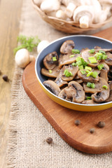 Delicious fried mushrooms in pan on table close-up