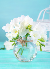 Beautiful freesia flowers, on blue wooden background