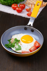 Scrambled eggs and bacon on frying pan on table close-up