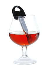 Composition with car key and glass of cognac, isolated on white