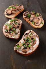 Delicious bruschetta with mushrooms on table close-up