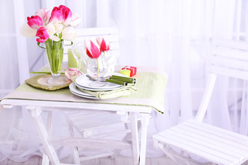 New table and chairs with place settings on light background