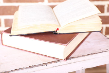 Books on wooden ladder on  color wall background