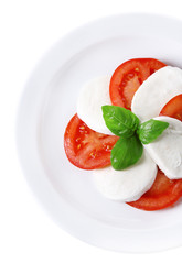 Caprese salad with mozarella cheese, tomatoes and basil