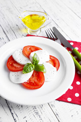 Caprese salad with mozarella cheese, tomatoes and basil