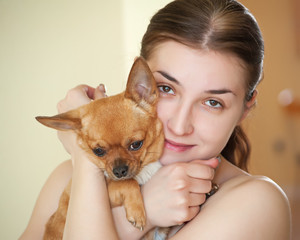 Happy girl with chihuahua dog in arms.