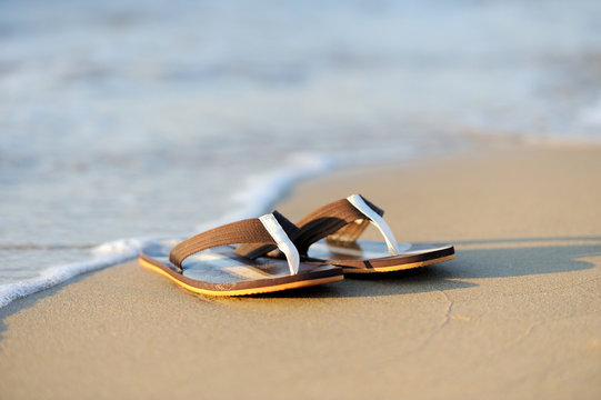Flip flops on a sandy ocean beach