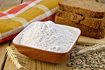 Flour rye in bowl with bread on board