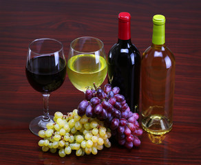 Fototapeta na wymiar Bottles of Red and White Wine with Fresh Grapes. Glasses of Wine