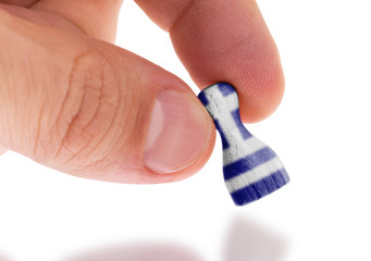 Hand holding wooden pawn, flag painting, selective focus