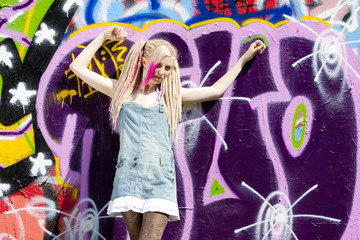 young woman standing at graffitti wall