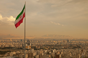 Iran Flag in the Wind Above Skyline of Tehran