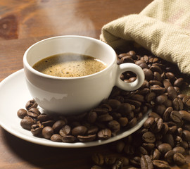 Kaffeetasse und Körner auf Holztisch