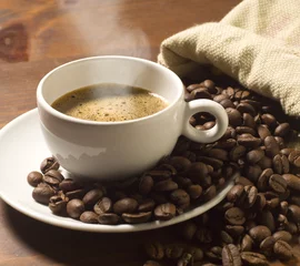 Foto auf Acrylglas Kaffee Bar Kaffeetasse und Körner auf Holztisch