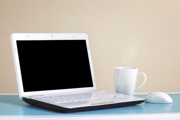 Fototapeta premium White laptop on table - place for text.