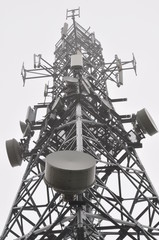 Telecommunication tower with antennas in the mist 