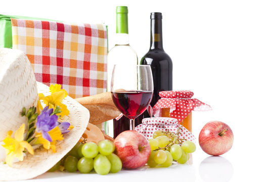 picnic basket with bottle of wine,fruits, bread and summer hat 