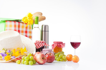 picnic basket with bottle of wine,fruits, bread and summer hat 