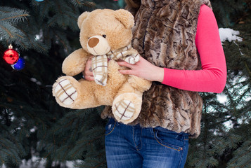 Woman in winter dress with teddy bear