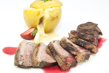 roast goose breast with apple sauce on white plate