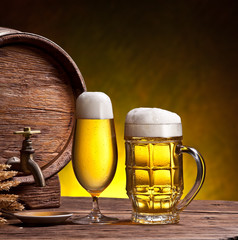 Beer glasses, old oak barrel and wheat ears.