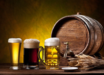 Beer glasses, old oak barrel and wheat ears.