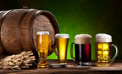 Beer glasses, old oak barrel and wheat.