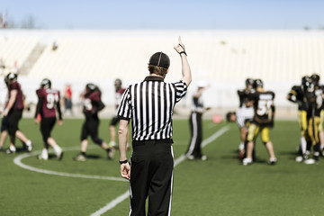 American football referee with hand up